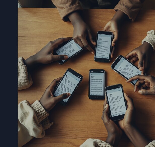 Several Black women's hands gathered around a wood table, each holding a phone open to the same group chat, no document anywhere on the table.