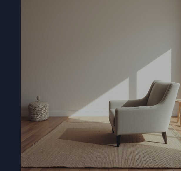 A warm minimal living room mid-rearrangement, a single armchair pushed a few feet from its old spot on the rug, nobody in the room moving it.