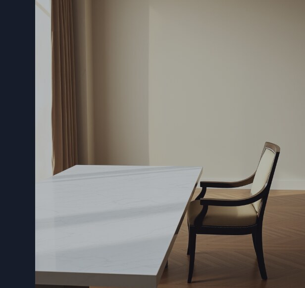 A single elegant dining chair pulled up to a long marble table, noticeably lower than every other seat, so whoever sits there is beneath the surface line.